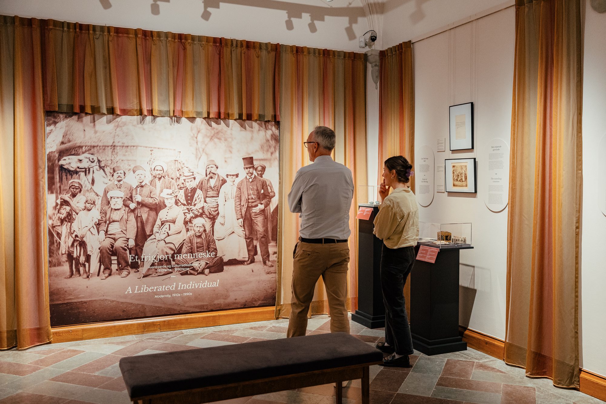 Danner af Danmark at Frederiksborg Slot, visitors in front of a large historical photograph framed by curtains