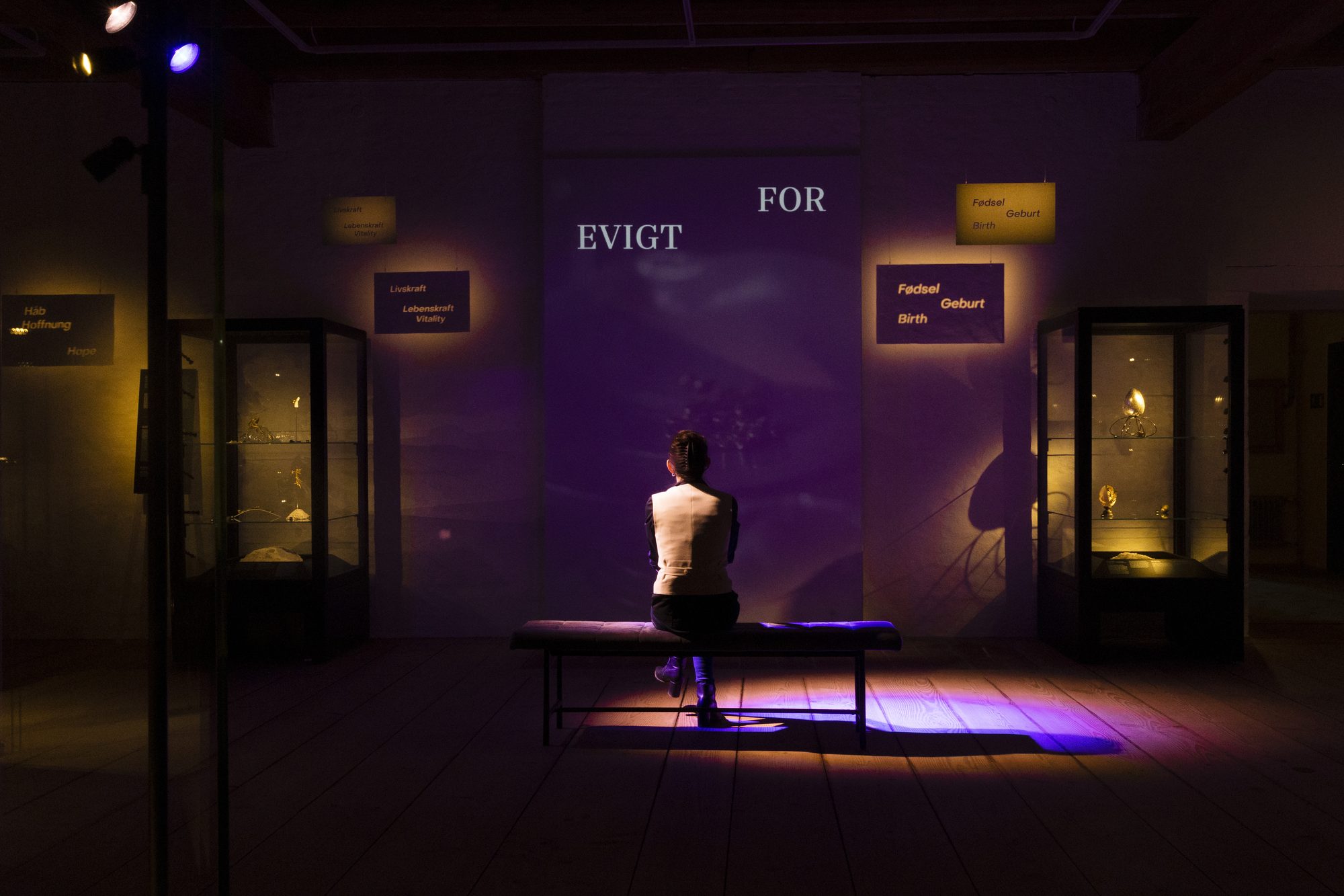 Makabre Mesterværker, visitor seated alone in the purple-lit room For evigt